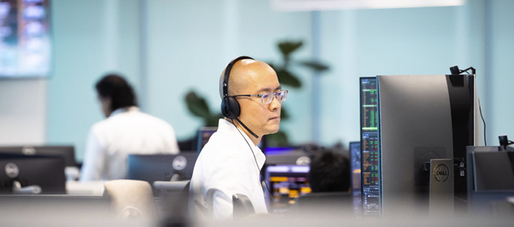Employee working at a desk with headset in the Singapore office.