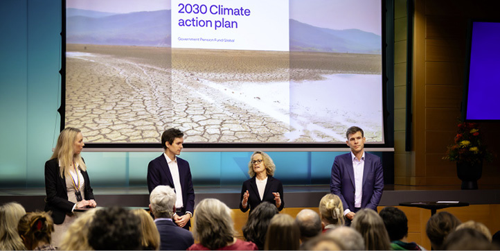Speakers on stage presenting the 2030 Climate Action Plan to an audience.