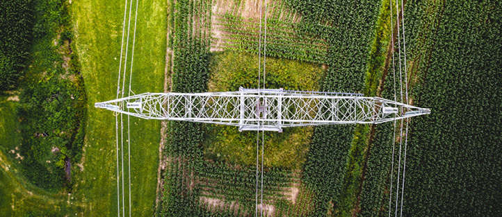 Aerial view of a power transmission tower above agricultural fields.