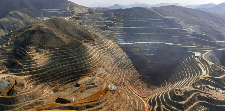 Aerial view of a large open-pit mine in a mountainous landscape.Aerial view of a large open-pit mine in a mountainous landscape.