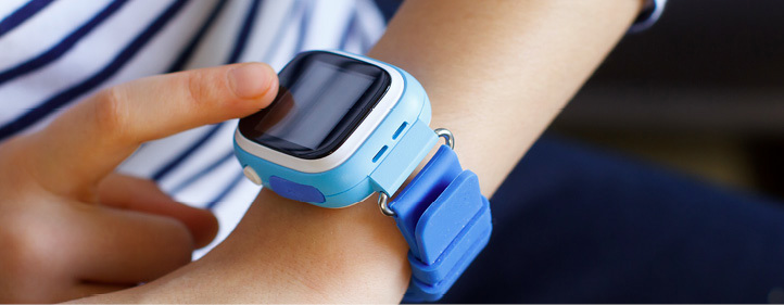 Child wearing a smartwatch and touching the screen.