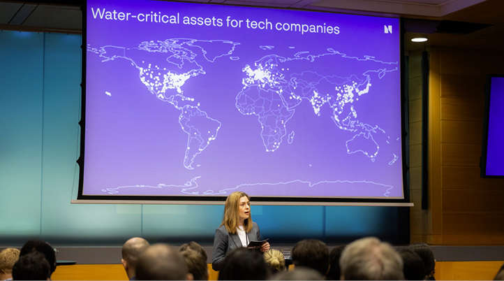 Innleder foran en presentasjon med tittelen «Water-critical assets for tech companies», med verdenskart og markerte lokasjoner.