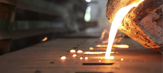 Smeltet metall som helles i et industrielt miljø.