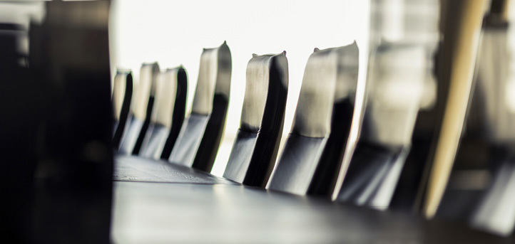 Rekke med tomme stoler langs et konferansebord.