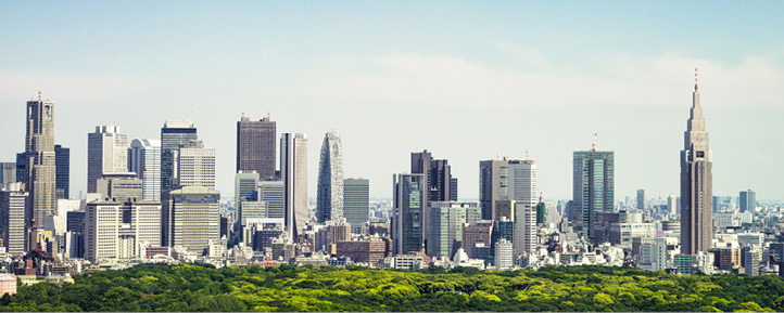 Bysilhuett med høyhus som reiser seg over en stor grønn park.